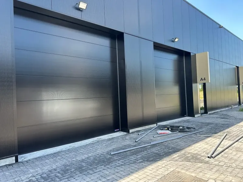 Zwarte gevel en industriele poorten na de reiniging